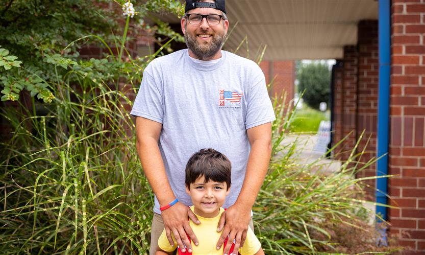 A parent and student smile
